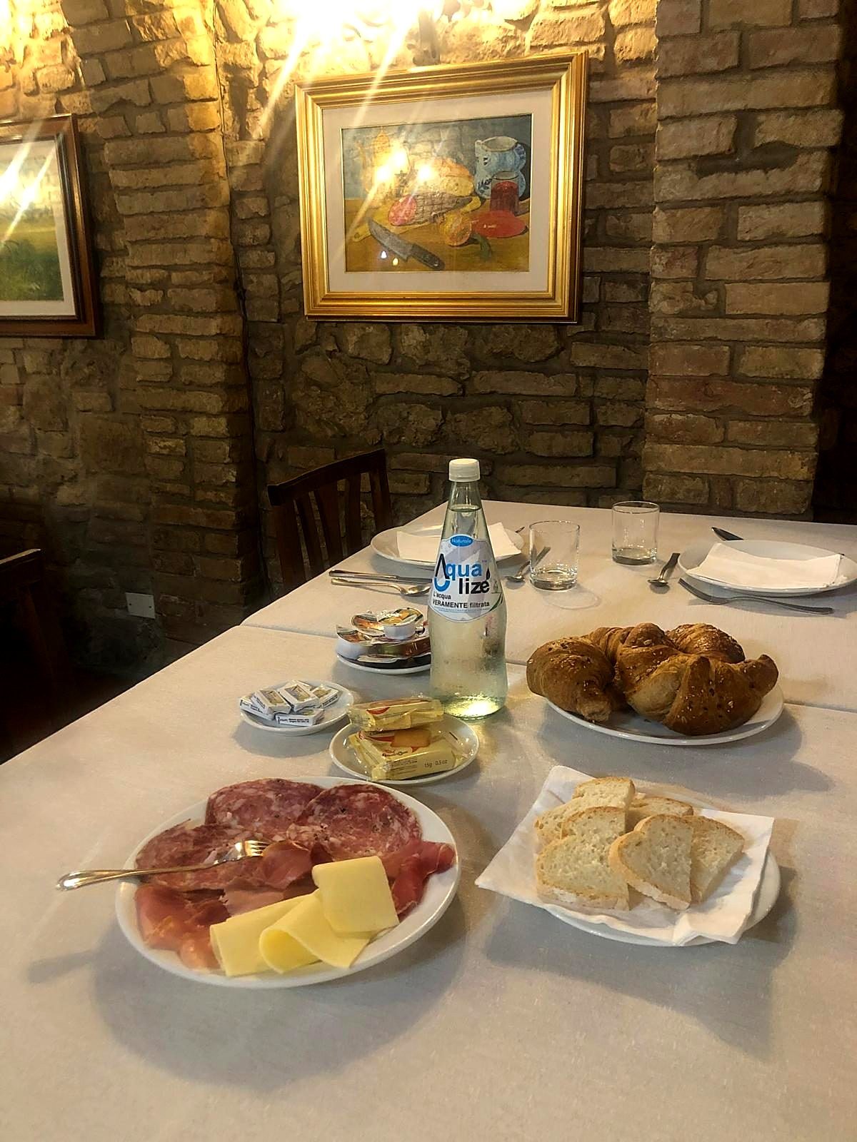 Colazione salata con salumi, formaggio e pane toscano nella sala in pietra